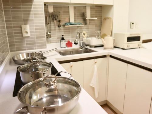 a kitchen with two pots on a stove at Cozy Seomyeon House in Busan