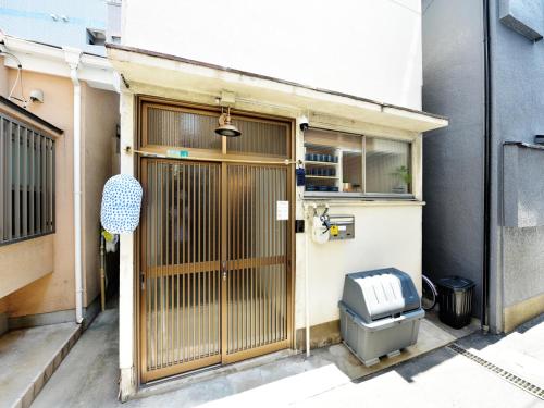 WadaにあるOpen Sale! Umeda 3 min away 2BR Max6 Free tour guideの木製のドアのある建物の入り口