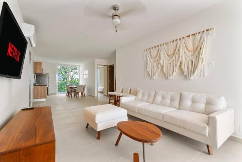 a living room with a white couch and a table at Casa Akumal Caribbean Sea Views Walk To Beach 11 Pools in Akumal