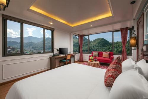 a bedroom with a large bed and large windows at Glow Sapa Hotel in Sa Pa