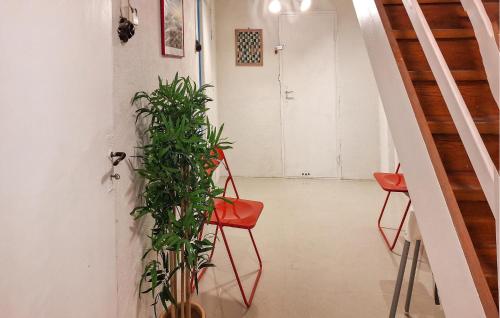 a hallway with two red chairs and a plant at Stunning Home In Mariannelund With Wifi in Mariannelund