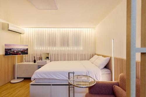 a bedroom with a bed and a table and a chair at Bom Noon Stay Jamsil 봄눈스테이 잠실 in Seoul