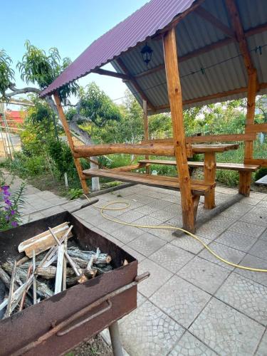a wooden picnic table with a roof on a patio at Bugazik in Karolino-Buhaz