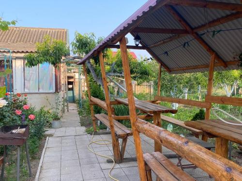 a wooden bench in a garden with a pavilion at Bugazik in Karolino-Buhaz