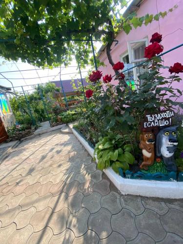 a garden in front of a pink house with flowers at Bugazik in Karolino-Buhaz