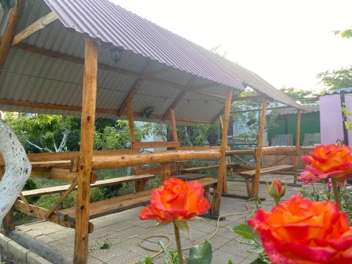 a wooden pavilion with red flowers in front of it at Bugazik in Karolino-Buhaz