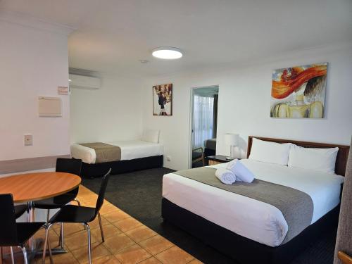 a hotel room with two beds and a table at Cleveland Motor Inn in Cleveland
