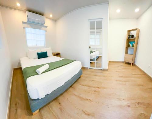 a bedroom with a large bed and a wooden floor at Zaba Beach House in San Andrés
