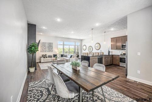 a kitchen and living room with a wooden table and chairs at Modern 3-Story Townhome in Omaha