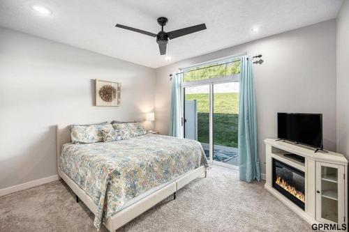 a bedroom with a bed and a flat screen tv at Modern 3-Story Townhome in Omaha