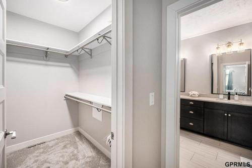 a bathroom with a sink and a mirror at Modern 3-Story Townhome in Omaha