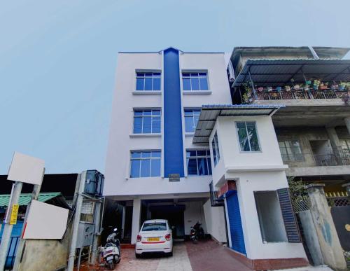 a white building with a car parked in front of it at Hotel O Sai villa in Dispur