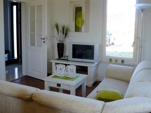 a living room with a couch and a table with a tv at Holiday home in the Lüneburg Heath in Wietzendorf