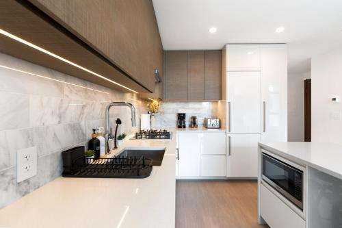 Modern 1BR Condo, Sleeps 4 with Views, AC, Balcony, Near SkyTrainにあるキッチンまたは簡易キッチン