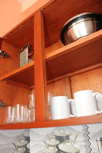 a cupboard with cups and a bowl on top at Hostal Corazon A Corazon in Chiclayo