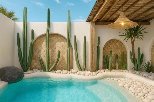 a swimming pool with cactus and a house at Kaleydo Villas in Gili Trawangan