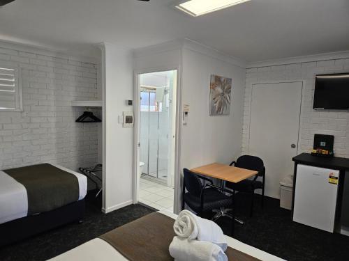 a bedroom with a bed and a desk and a table at Cleveland Motor Inn in Cleveland