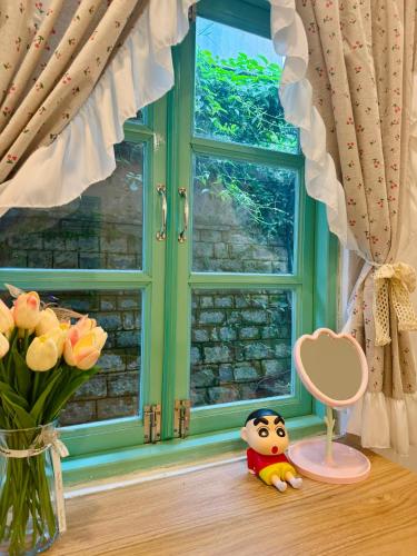 a toy doll sitting on a window sill next to a window at Lyan Garden in Da Lat
