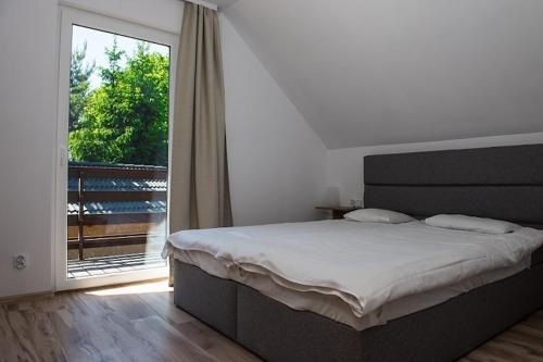una camera da letto con un letto e una grande finestra di Comfortable, two-story holiday home, summer pool a Jarosławiec