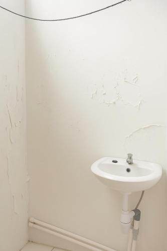 a white bathroom with a sink and a shower at Citytel Kostel in Lampung