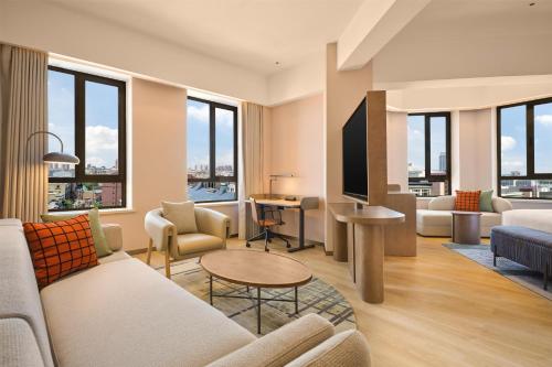 a living room with a couch and a table at Hilton Garden Inn Yingkou Zhanqian in Yingkou