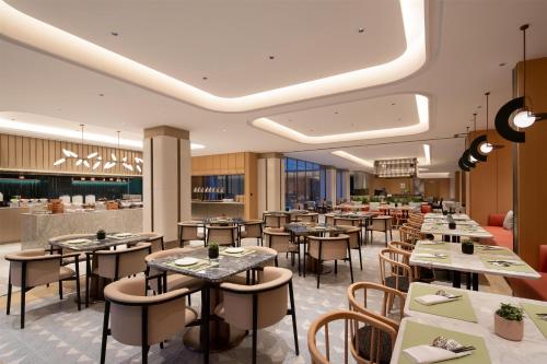 a restaurant with tables and chairs and a bar at Hilton Garden Inn Shaoxing Yuecheng in Shaoxing