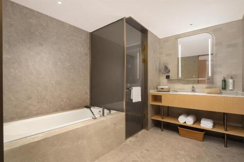 a bathroom with a tub and a sink at Hilton Garden Inn Shaoxing Yuecheng in Shaoxing
