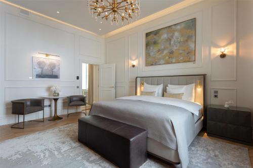 a bedroom with a bed and a table and a chandelier at The Hotel Maria Helsinki in Helsinki