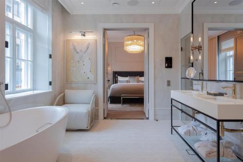 a bathroom with a bath tub and a bedroom at The Hotel Maria Helsinki in Helsinki