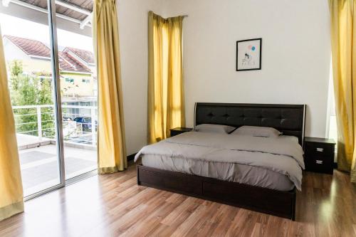 a bedroom with a large bed and yellow curtains at Holiday Home By Island Hospitality in Teluk Bahang