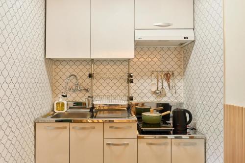 a kitchen with white cabinets and a sink at Bom Noon Stay Jamsil 봄눈스테이 잠실 in Seoul