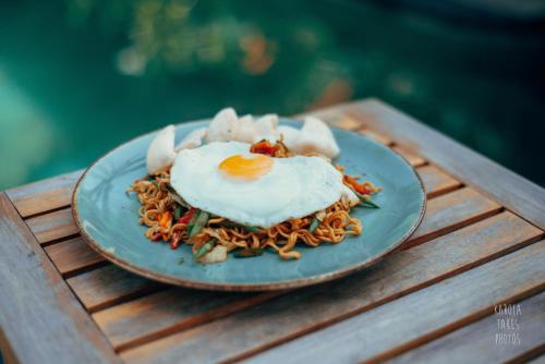 吉利特拉旺安椰子花园度假酒店的面条上带鸡蛋的食品盘