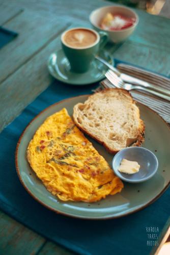 吉利特拉旺安椰子花园度假酒店的盘子,夹煎蛋,烤面包和一杯咖啡