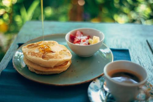 吉利特拉旺安椰子花园度假酒店的盘薄煎饼和一杯咖啡在桌子上
