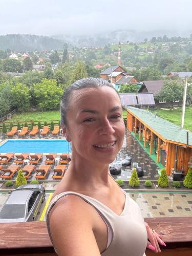 a woman standing on the balcony of a resort at Готель TWINS РАЙ in Vorokhta