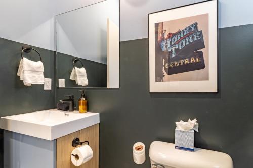 a bathroom with a white sink and a toilet at The Conway by AvantStay Modern Comfort Near Downtown Nashville in Nashville
