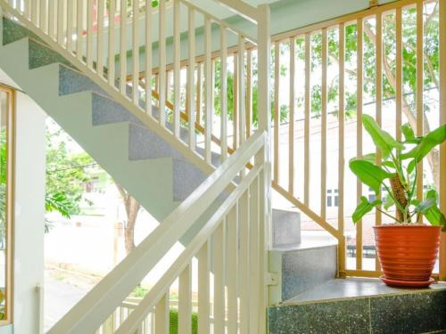 a staircase with a potted plant in a room at Hotel Tiara Family Residence Batu by NAP in Batu