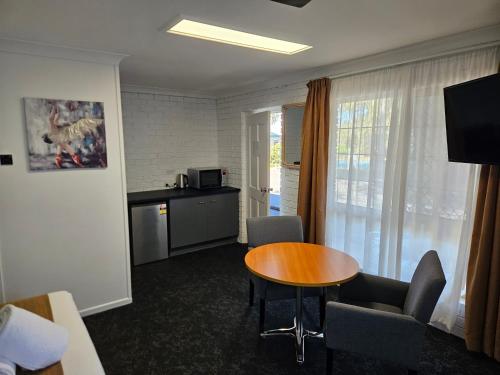 a hotel room with a table and chairs and a kitchen at Cleveland Motor Inn in Cleveland