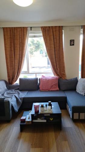 a living room with a blue couch and a table at Casabeach in Melbourne