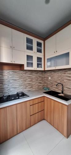 a kitchen with wooden cabinets and a sink at Emerald Villa in Prampuan