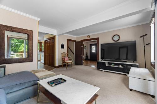 a living room with a couch and a tv at Grammy's Famous Lake House Retreat in East Hampton
