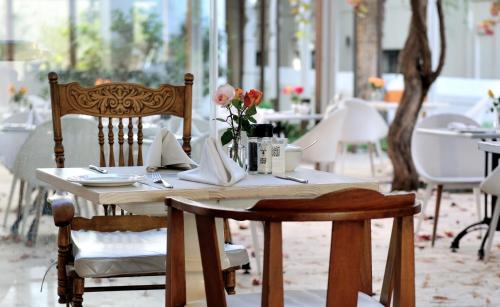 a wooden table with flowers on it in a restaurant at Oude Werf Hotel in Stellenbosch