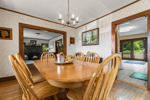 a dining room with a wooden table and chairs at Grammy's Famous Lake House Retreat in East Hampton