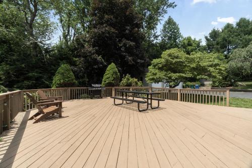two benches on a wooden deck with a fence at Grammy's Famous Lake House Retreat in East Hampton