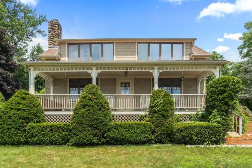 a large house with bushes in front of it at Grammy's Famous Lake House Retreat in East Hampton