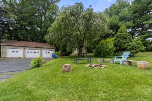 a yard with two blue chairs in the grass at Grammy's Famous Lake House Retreat in East Hampton