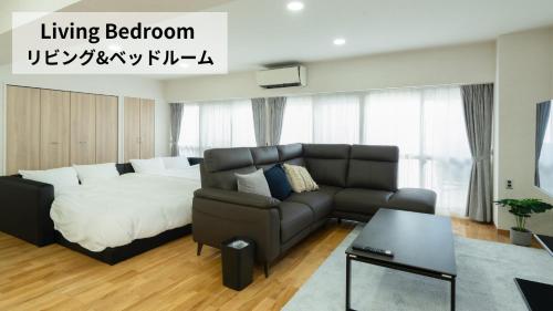 a living room with a bed and a couch at CleanNest Hokkaido Sapporo Kita33jyou in Sapporo