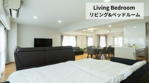 a living room with a bed and a dining room at CleanNest Hokkaido Sapporo Kita33jyou in Sapporo