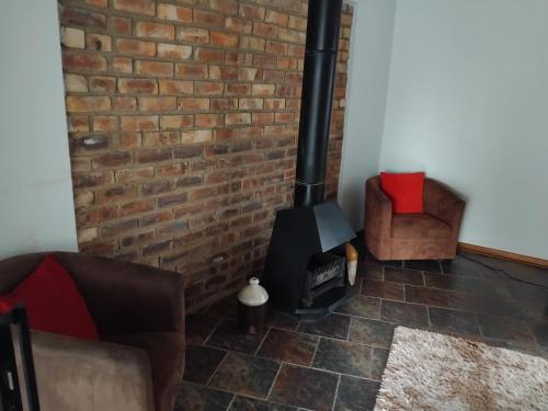 a brick wall and a wood stove in a living room at Heather Guest House in Alberton