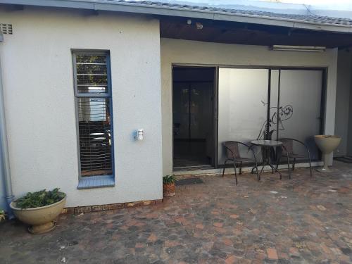 a patio of a house with a table and chairs at Heather Guest House in Alberton